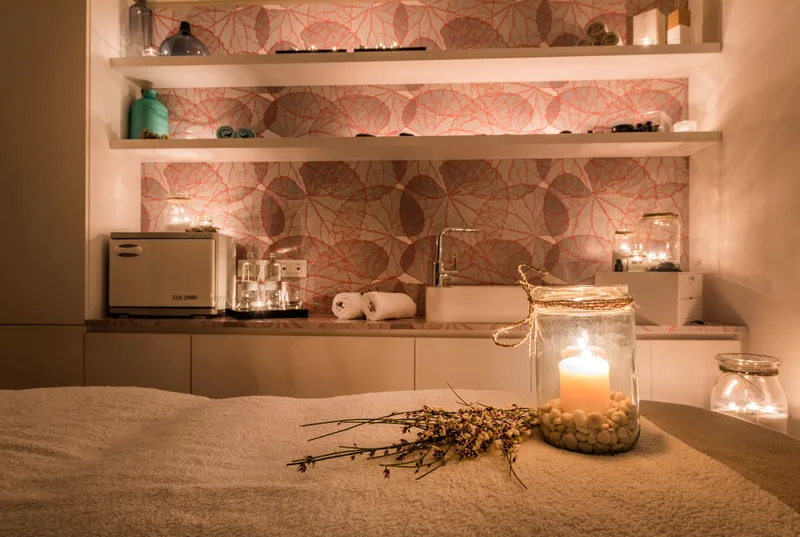 Il lettino della cabina preparato, con la candela accesa e i fiori secchi